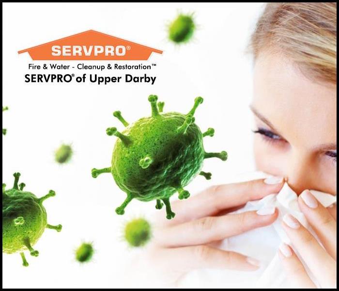 Female holding a tissue to her nose with flu virus in the air