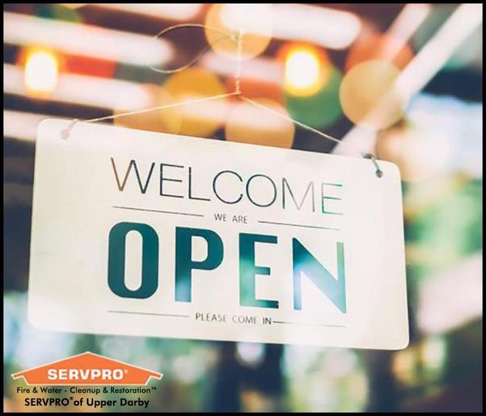Welcome We Are Open, Please Come In hanging on a retail store's door